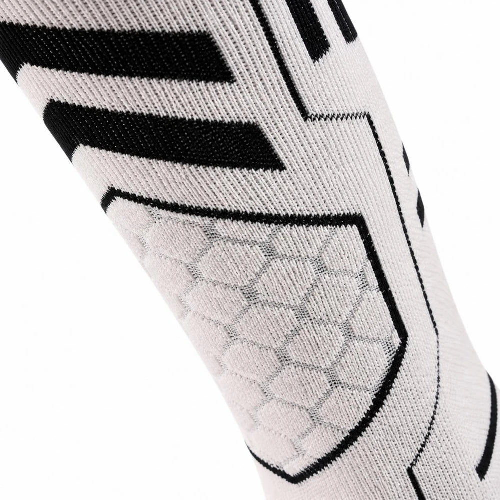 Close-up of the honeycomb arch support band on white Merino blend ski socks.