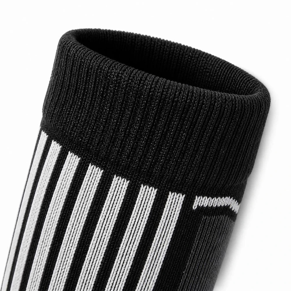 Close-up of the ribbed cuff on black merino wool ski socks showing elasticity.
